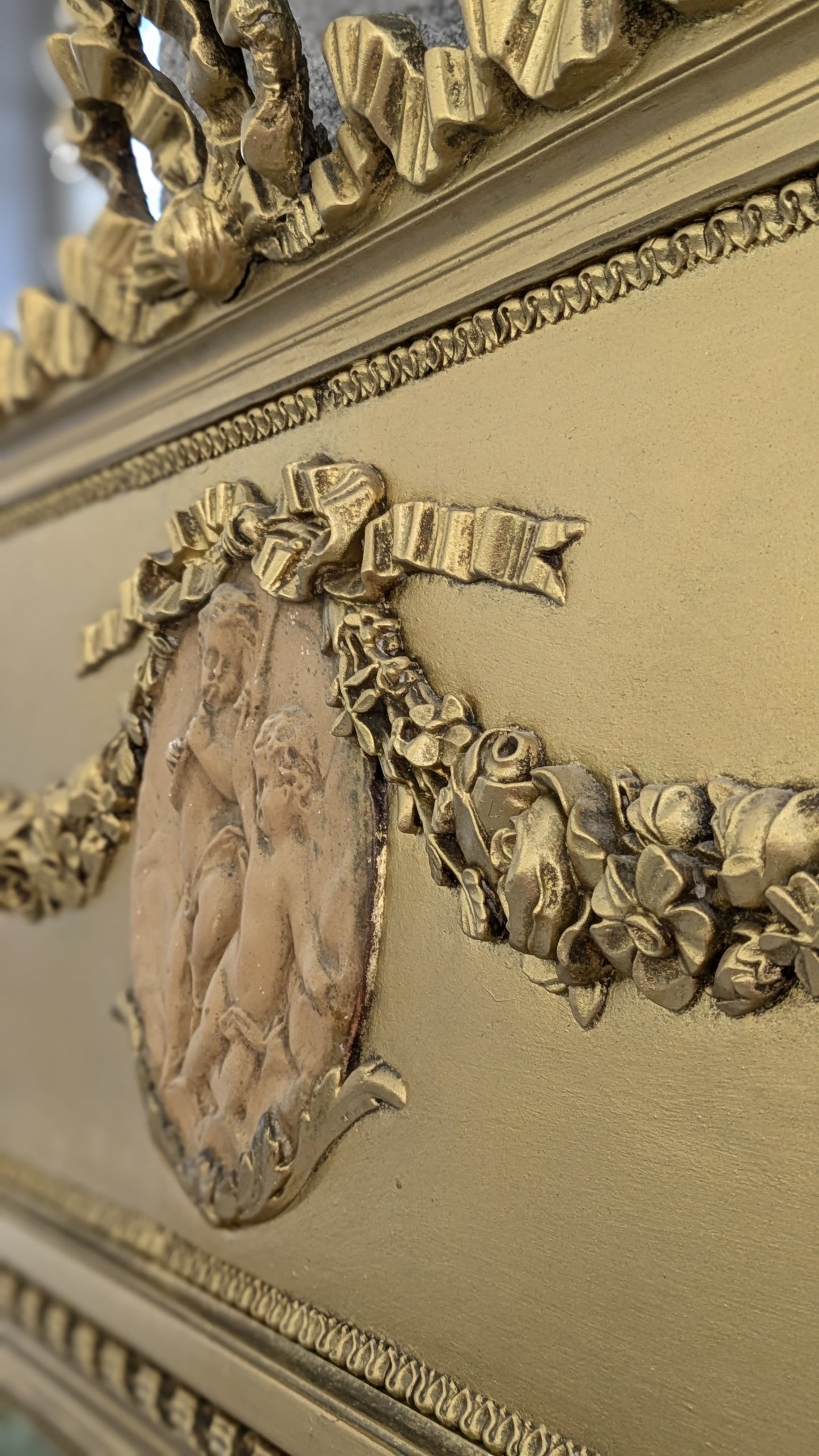 Magnifique miroir trumeau ancien en bois doré. Cadre sculpté, glace biseautée, bas-relief de chérubins.