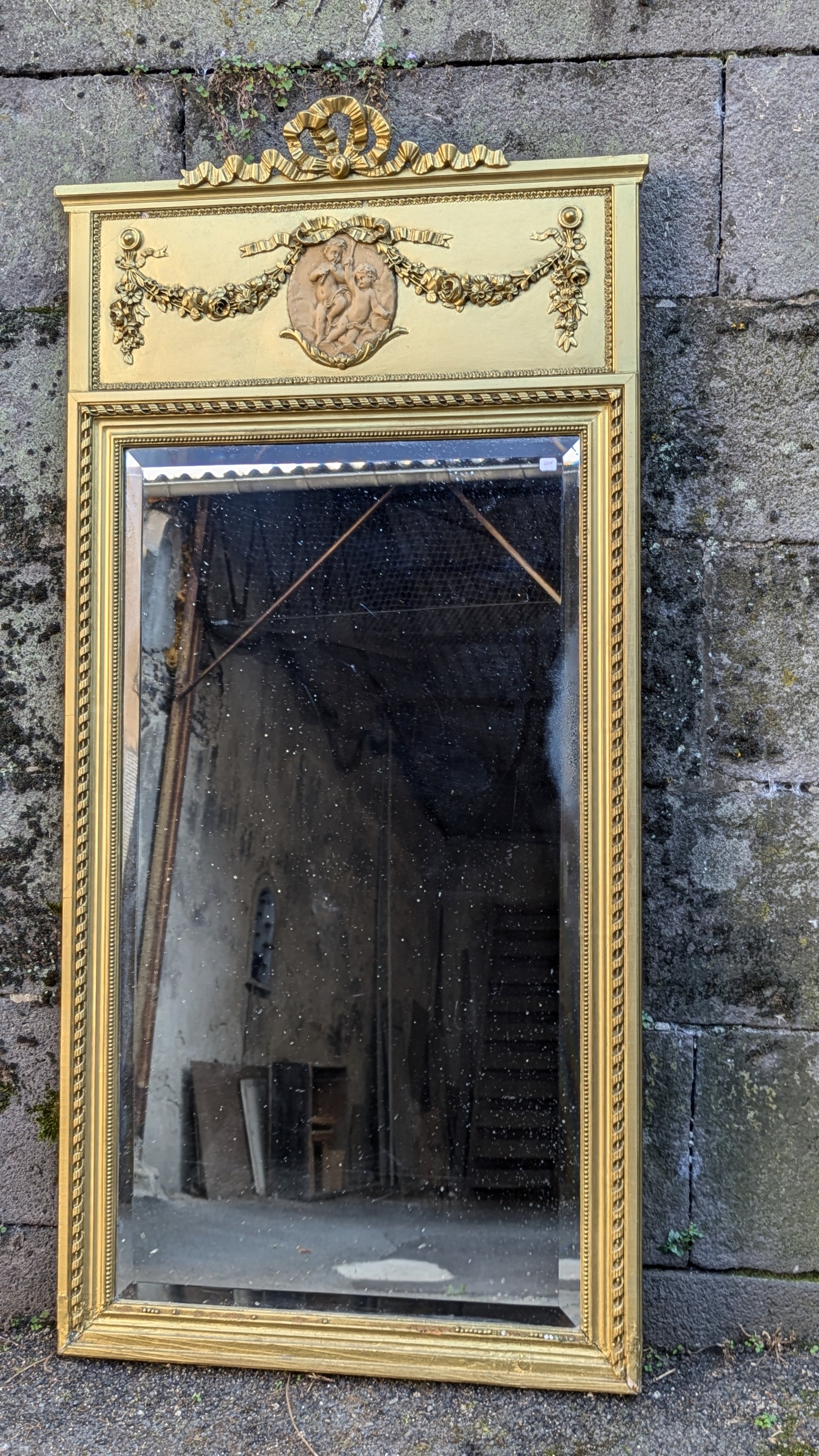 Magnifique miroir trumeau ancien en bois doré. Cadre sculpté, glace biseautée, bas-relief de chérubins.